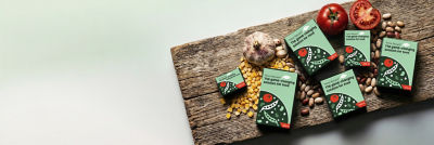 Tetra Recart carton packages, corn, beans and fresh tomatoes on wooden cutting board