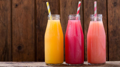 Three bottles with soft drinks and paper straws
