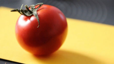 Tomato on yellow cutting board