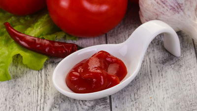 Salsa de tomate en un tazón blanco, tomates, chile y ajo a un lado