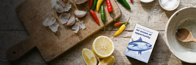 Tuna in Tetra Recart carton, lemon, garlic and chili on wooden tray