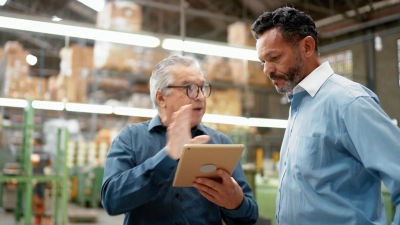 Two men discussing and holding an ipad