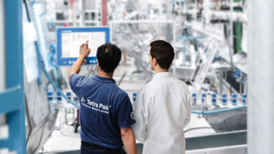 Dois homens olhando para a tela na fábrica de embalagens