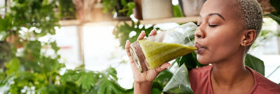 Donna che beve un salutare frullato verde
