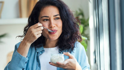 woman eating cottacge cheese from a bowl