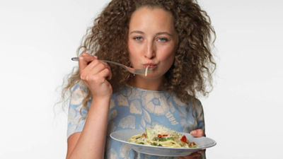 Woman eating pasta with cheese