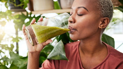 Woman drinking healthy green smoothie