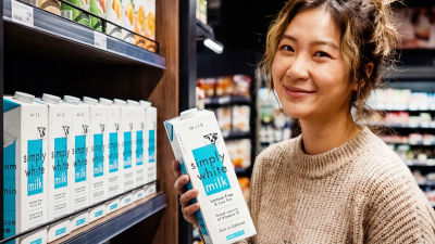 woman in a store holding a milk carton 