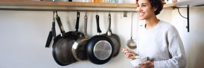 Woman in kitchen holding a bowl with cottage cheese.