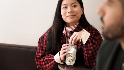 Woman with RTD coffee drink in Tetra Prisma Aseptic carton