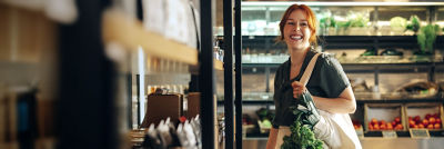 Woman with a bag in a supermarket with fresh vegetables