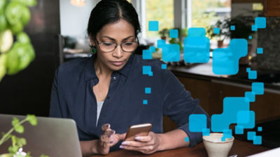 Woman with smartphone, home office
