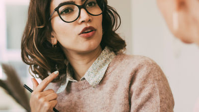 woman with glasses talking
