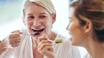Two women eating dessert, chocolate and vanilla pudding