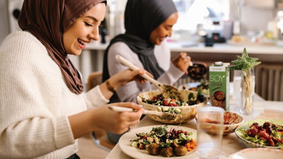 Women sitting at dinning table eating salad