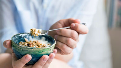 Eating yoghurt from a bowl with a spoon