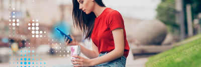 Young woman outside with phone and package
