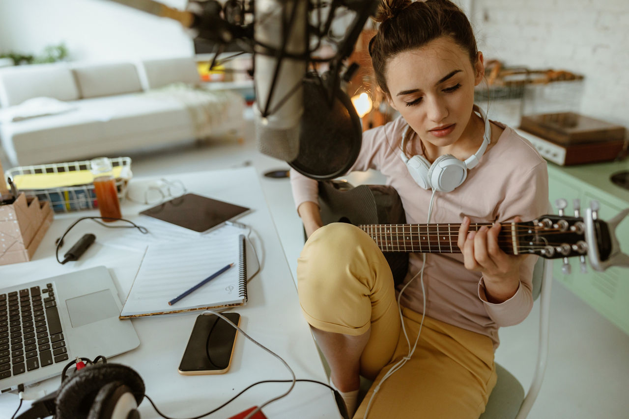 Photo of a young woman composing music in her home music studio
