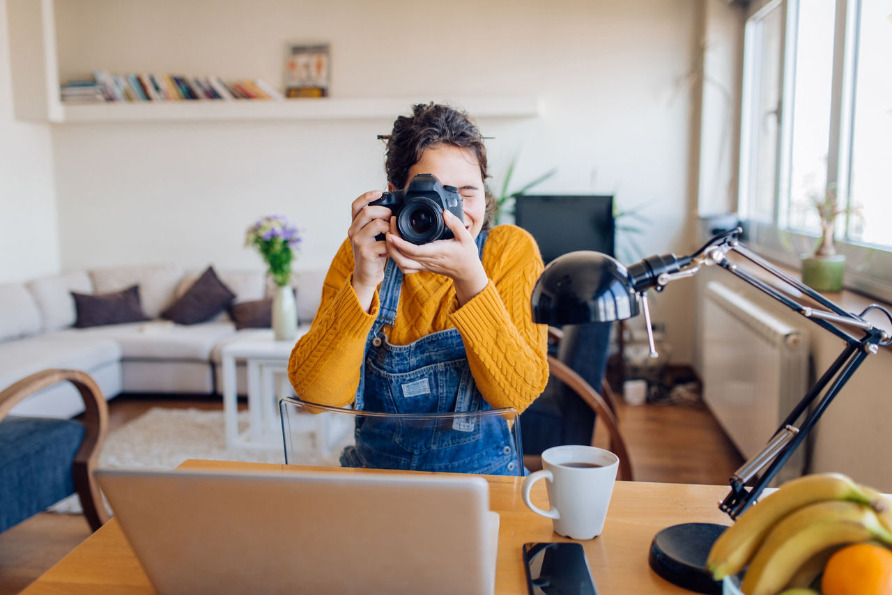 Young photographer working at her home office.