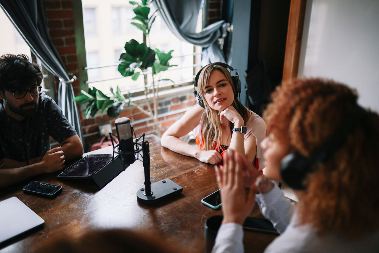 Group of people discussing themes on a live podcast from their studio in Los Angeles, California.