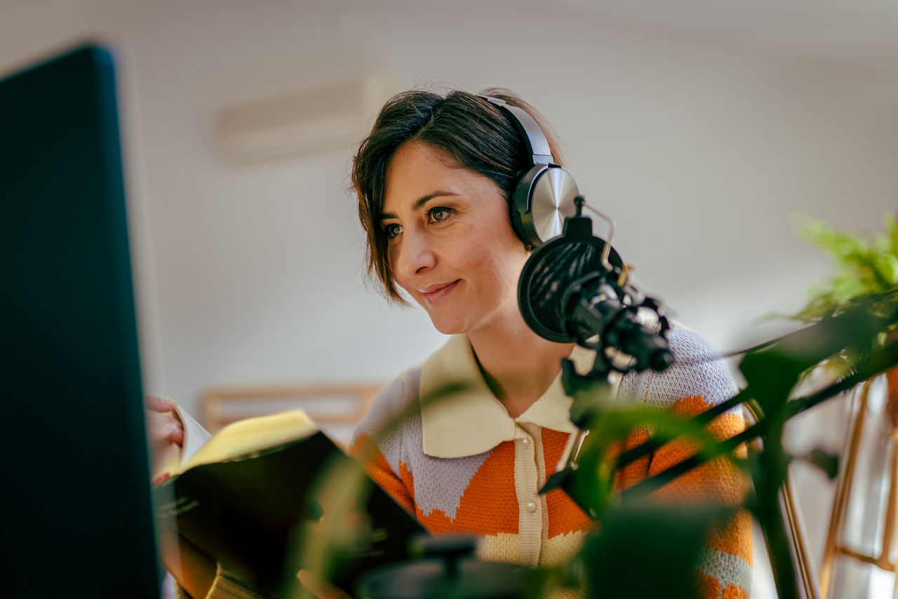 Beautiful young woman recording podcast