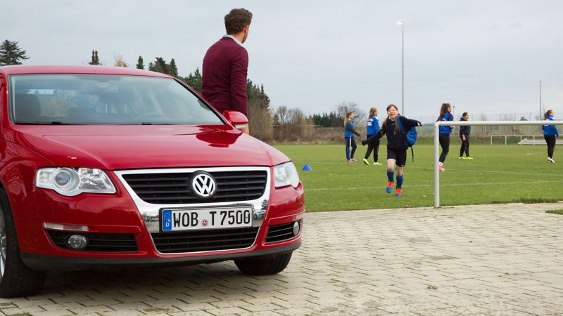 A father waits for his daughter, who just comes from football training at the family car – VW Passat B6