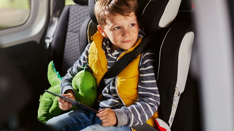 Un enfant assis à l'intérieur d'une Volkswagen sur un siége adapté
