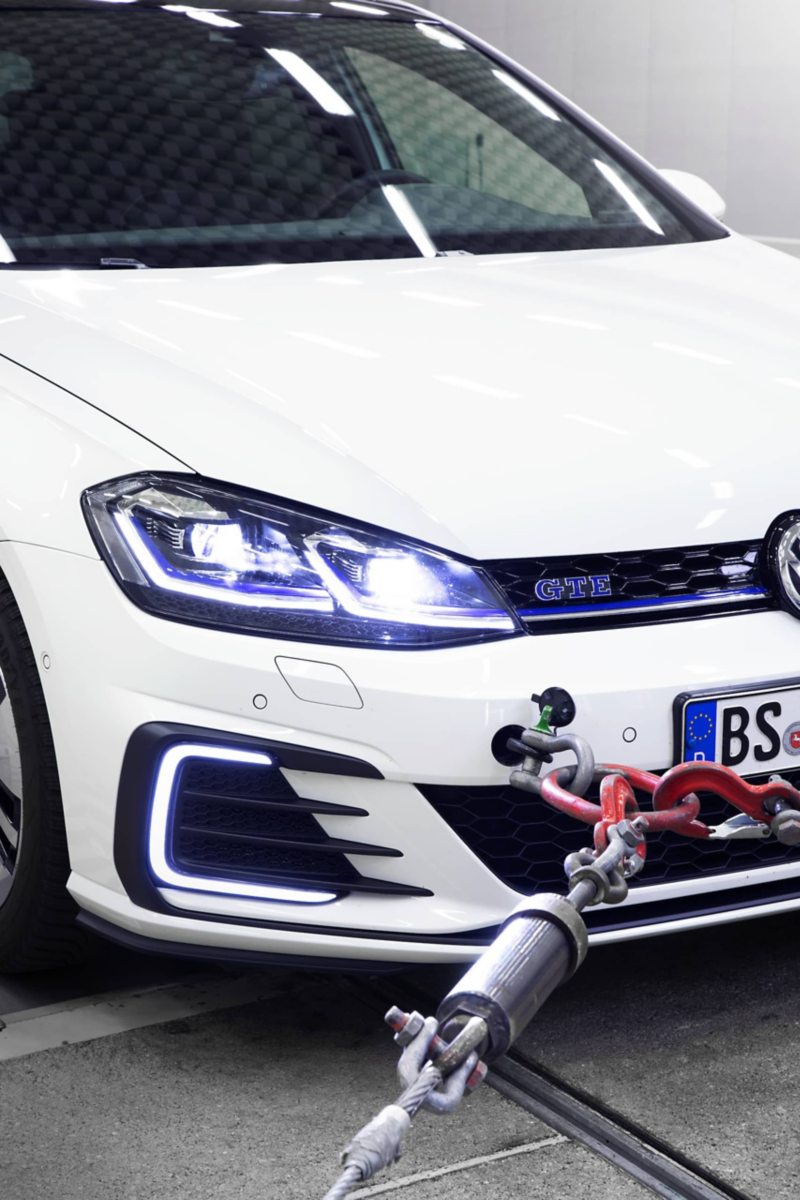 Detail view of the front of a Volkswagen on a dynamometer in the exterior noise hall