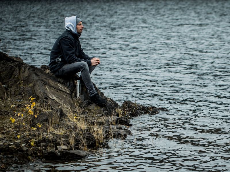 Christian Junker sits at a lake and prepares himself mentally for an excursion