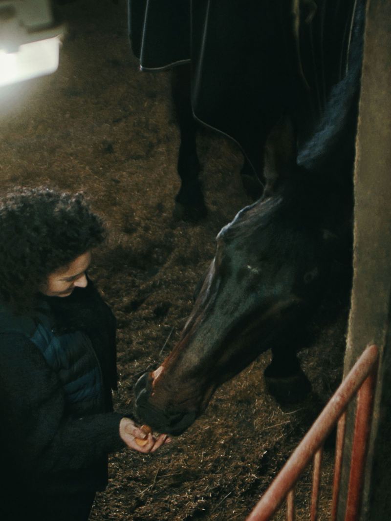 Janina Sandvoß feeds her horse in the stable