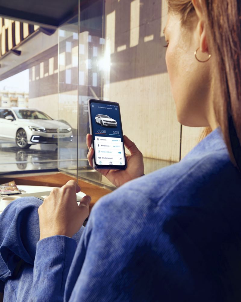 Mujer con smartphone conectada al Volkswagen Passat GTE con e-Remote