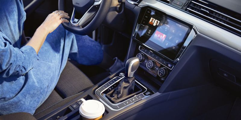 Mujer al volante de un Volkswagen Passat GTE, vista de la pantalla interactiva