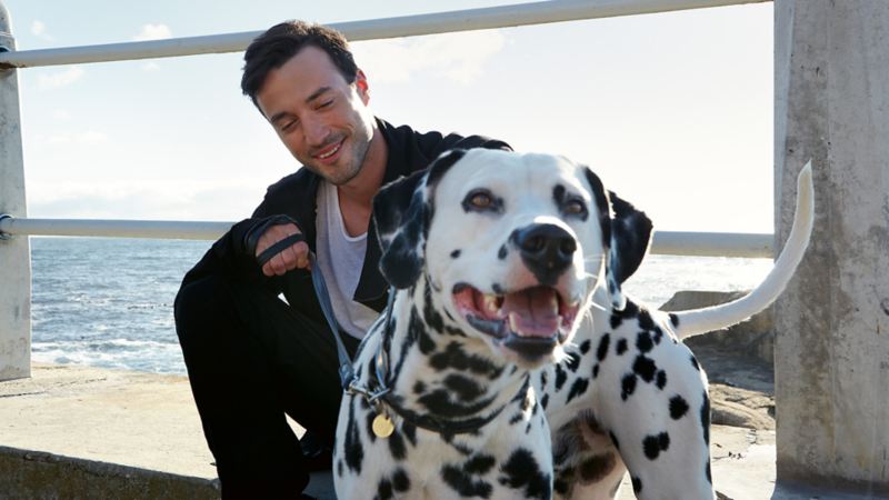 Άνδρας χαμογελαστός με τον σκύλο του - Χρηματοδότηση VW Auto Credit