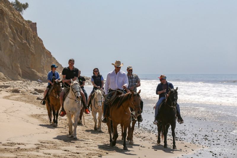 Te paard, op het strand