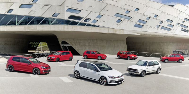 Rode en witte Volkswagen GTI's, verzameld voor een gebouw