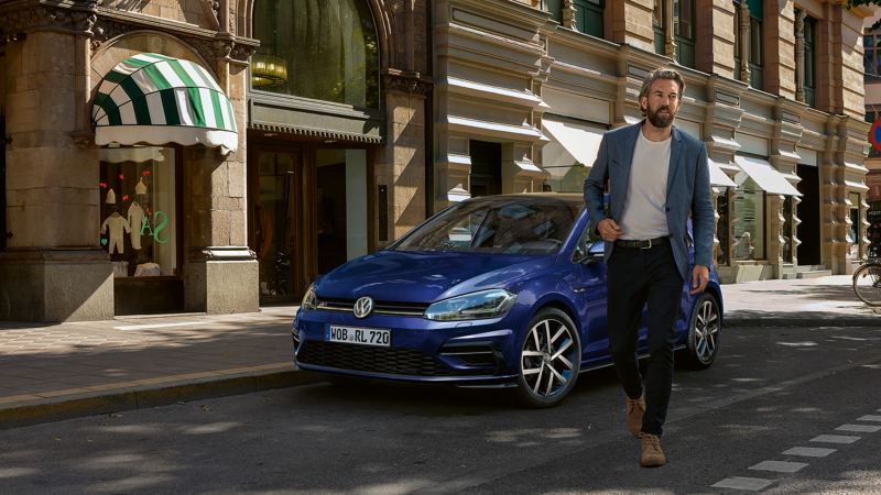 hombre alejándose de un volkswagen golf azul marino