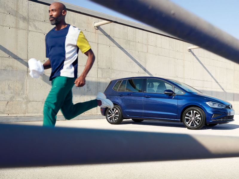 Mann enfernt sich joggend vom VW Golf Sportsvan UNITED