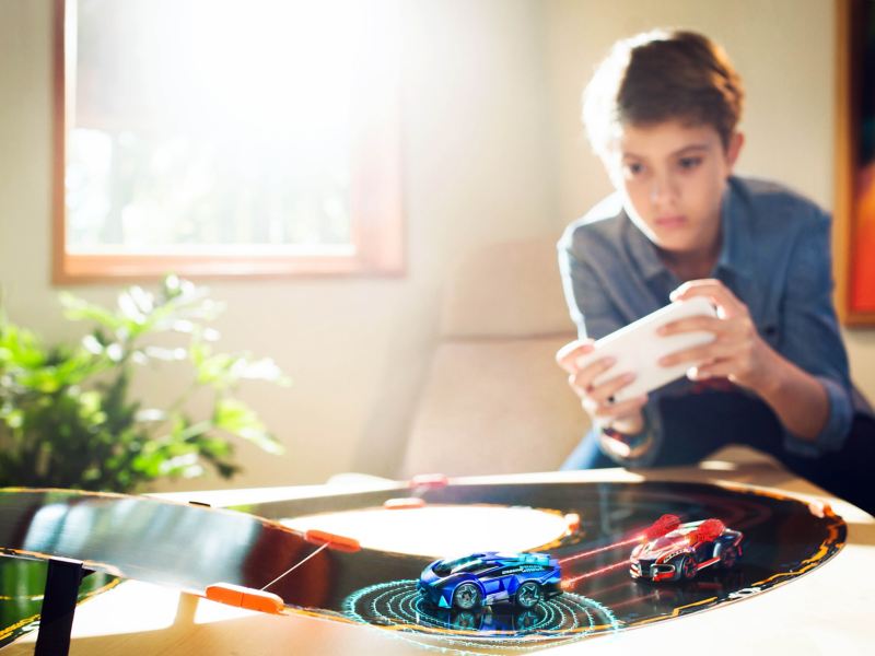 Bambino che gioca con Anki Overdrive in salotto