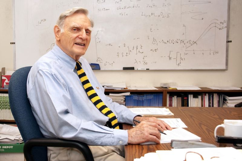 The inventor of the lithium battery sits at his desk.