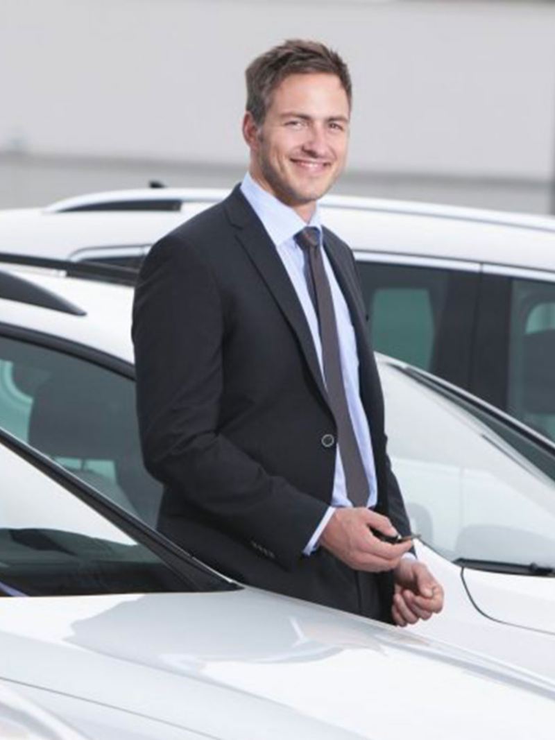 Un professionista insieme alle sue Volkswagen Business aziendali