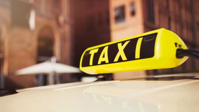 Insegna di taxi con scritta in giallo 