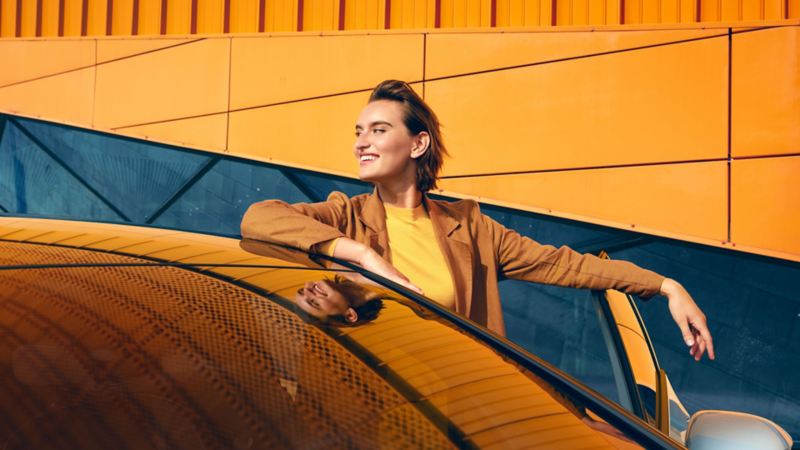 Una donna sorridente scende dalla VW ID.3