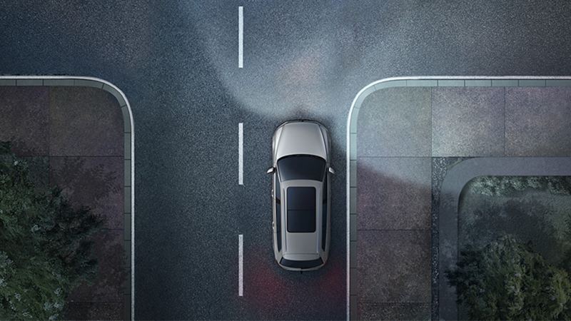 Rappresentazione grafica di una Volkswagen vista dall'alto su una strada di notte, con luci di svolta statiche e luci anteriori accese.