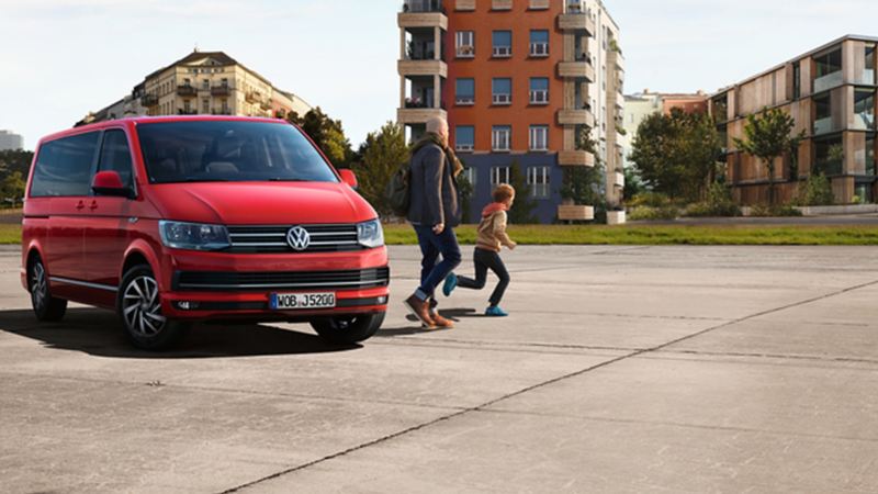 Une femme en skateboard passe devant une Volkswagen Up!
