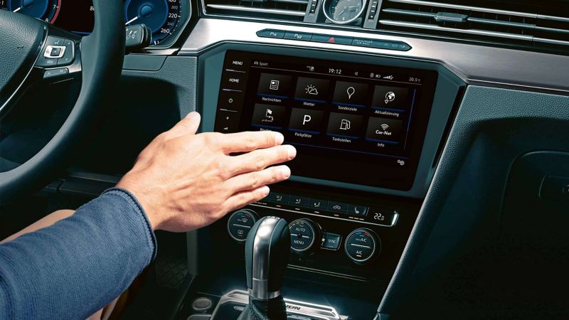 Un uomo al posto di guida di una Volkswagen gestisce il sistema di infotainment tramite i comandi gestuali, con semplici movimenti di una mano.