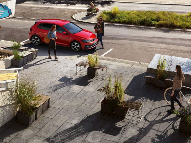 Volkswagen in manovra di parcheggio davanti a un posto, due persone in automobile