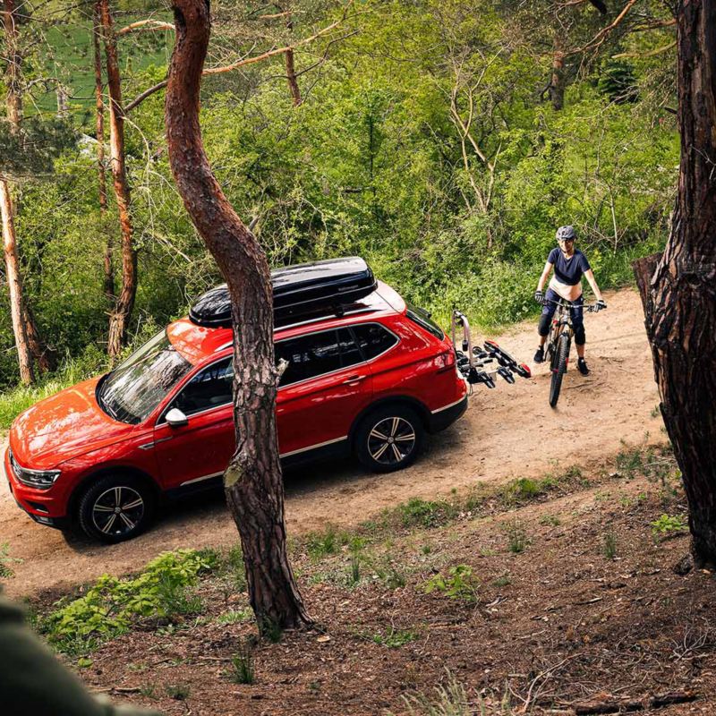Three siblings watch movies on a tablet while sitting on the back seat of a car – Volkswagen Accessories