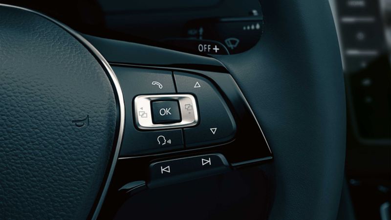 Dettaglio del sistema di comando vocale collocato sul volante di una Volkswagen.