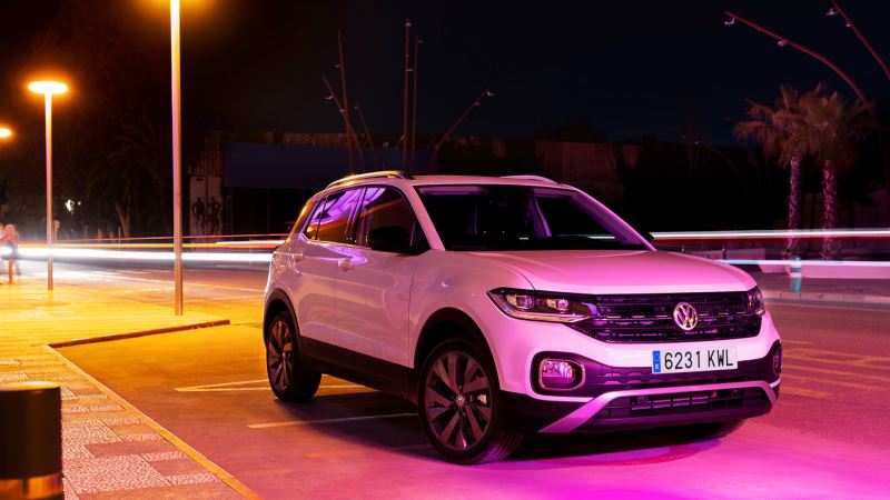 The white T-Cross in the neon light of the city