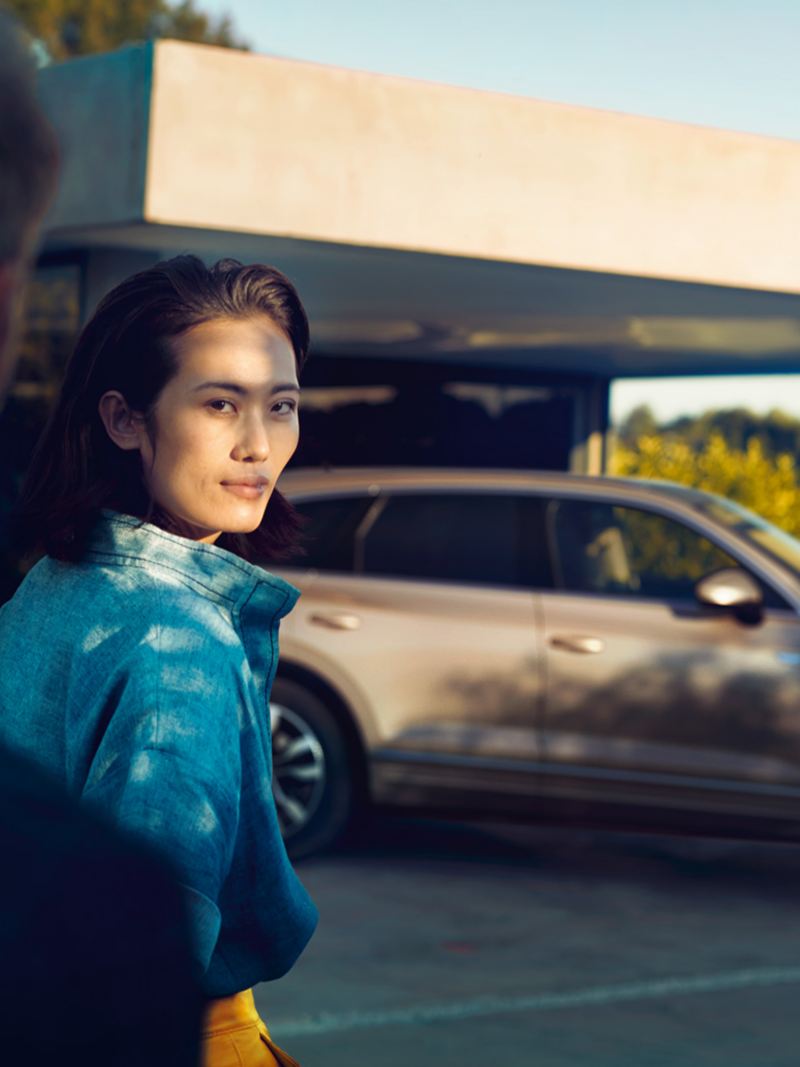 Kvinne ser på mann med Volkswagen VW Touareg i bakgrunnen